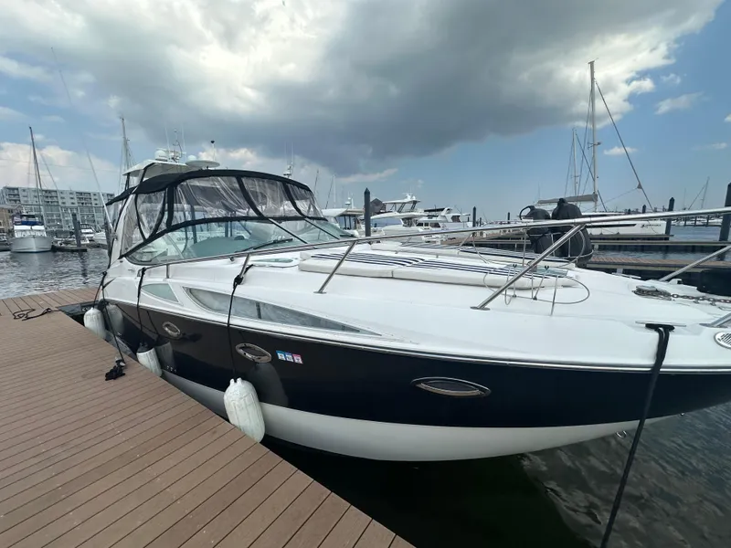 Slide: The Image of 2008 Bayliner 300SB boat docked at marina under cloudy sky. - 4