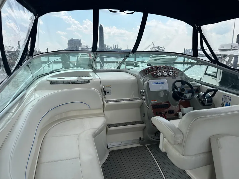 Slide: The Image of 2008 Bayliner 300SB boat interior with steering wheel and seating, docked at marina. - 6