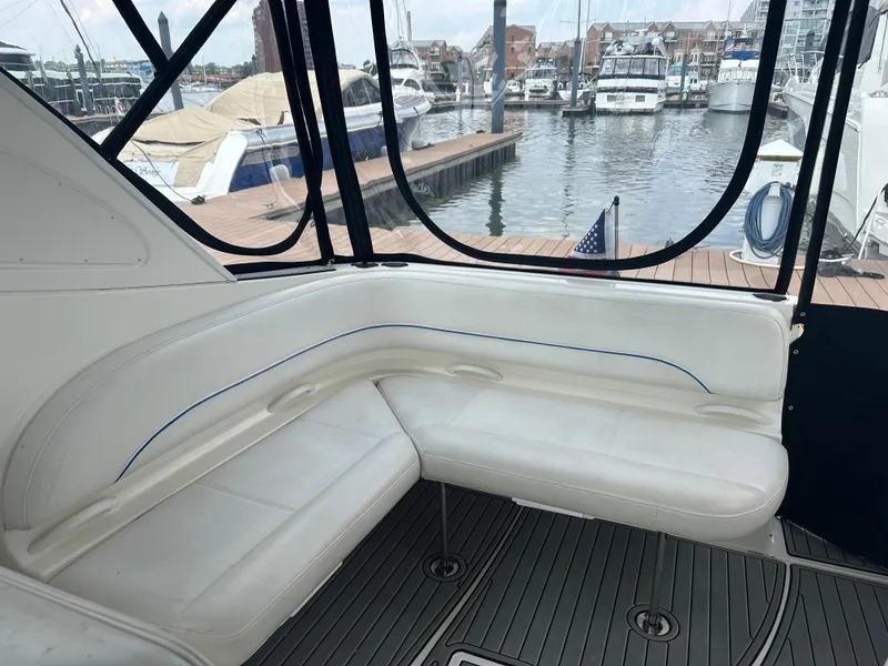 Slide: The Image of 2008 Bayliner 300SB boat interior with white seating, docked at a marina. - 7