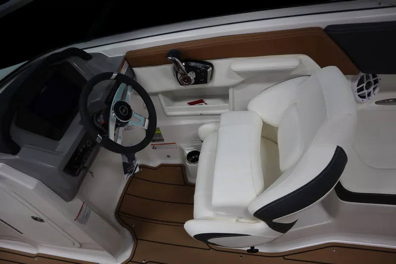 Slide: The Image of 2024 Chaparral 23 SSi boat interior with steering wheel and white seating. - 10