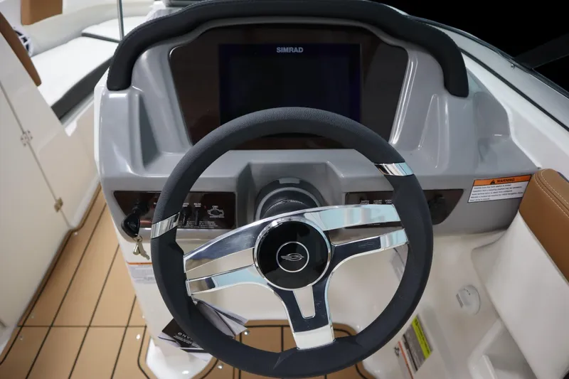 Slide: The Image of 2024 Chaparral 23 SSi boat dashboard with steering wheel and Simrad display. - 11