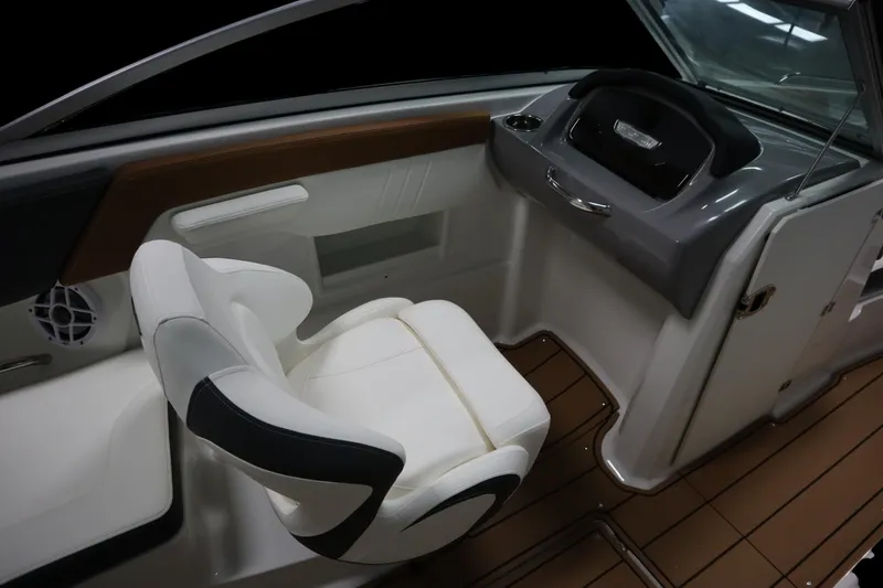 Slide: The Image of 2024 Chaparral 23 SSi boat interior with white captain's chair and sleek dashboard design. - 12