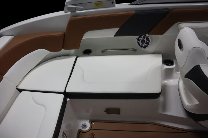 Slide: The Image of 2024 Chaparral 23 SSi boat interior with white and brown seating, speaker, and cup holder. - 13