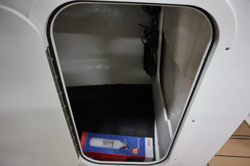Slide: The Image of Storage compartment in 2024 Chaparral 23 SSi boat, featuring a fire extinguisher. - 7