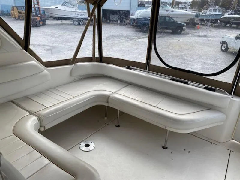 Slide: The Image of Interior seating of 1998 Sea Ray Sundancer 370 boat, featuring white cushioned benches. - 10