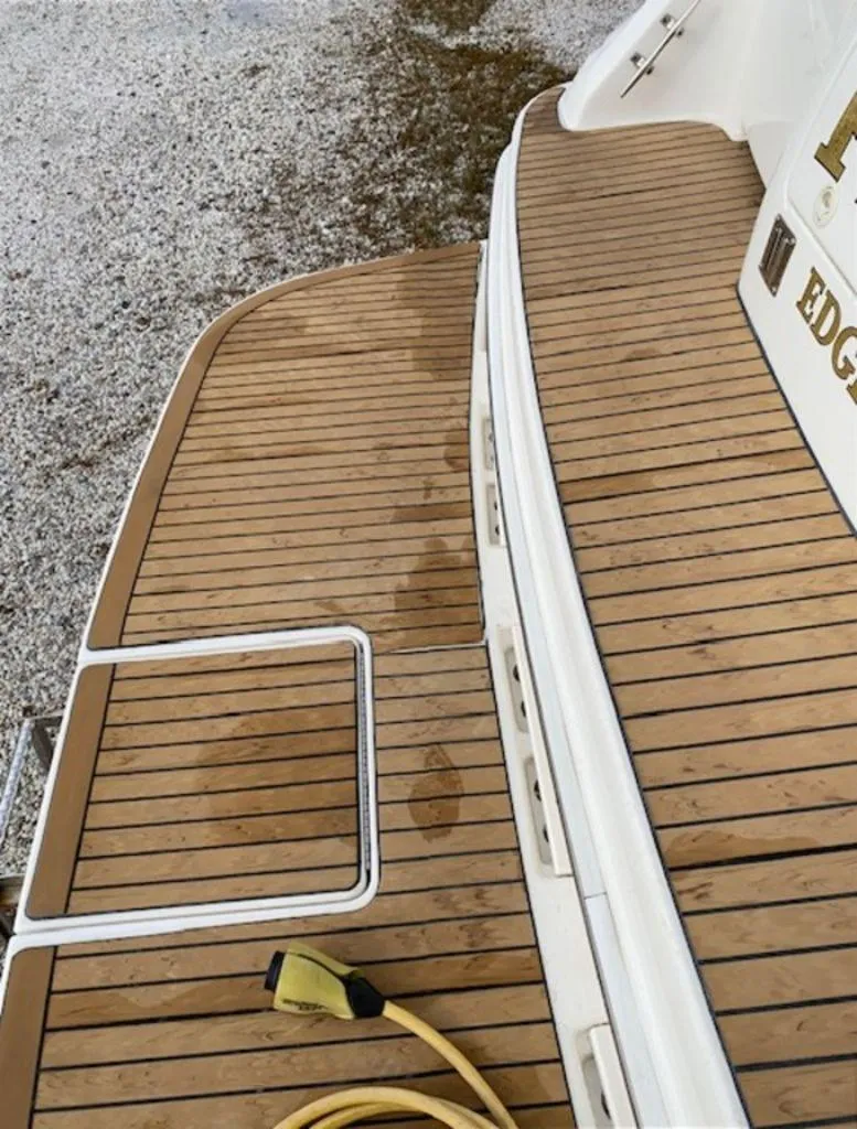 Slide: The Image of 1998 Sea Ray Sundancer 370 boat deck with teak flooring and power cord. - 13