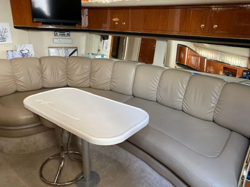 Slide: The Image of 1998 Sea Ray Sundancer 370 interior with beige leather seating and a white table. - 16