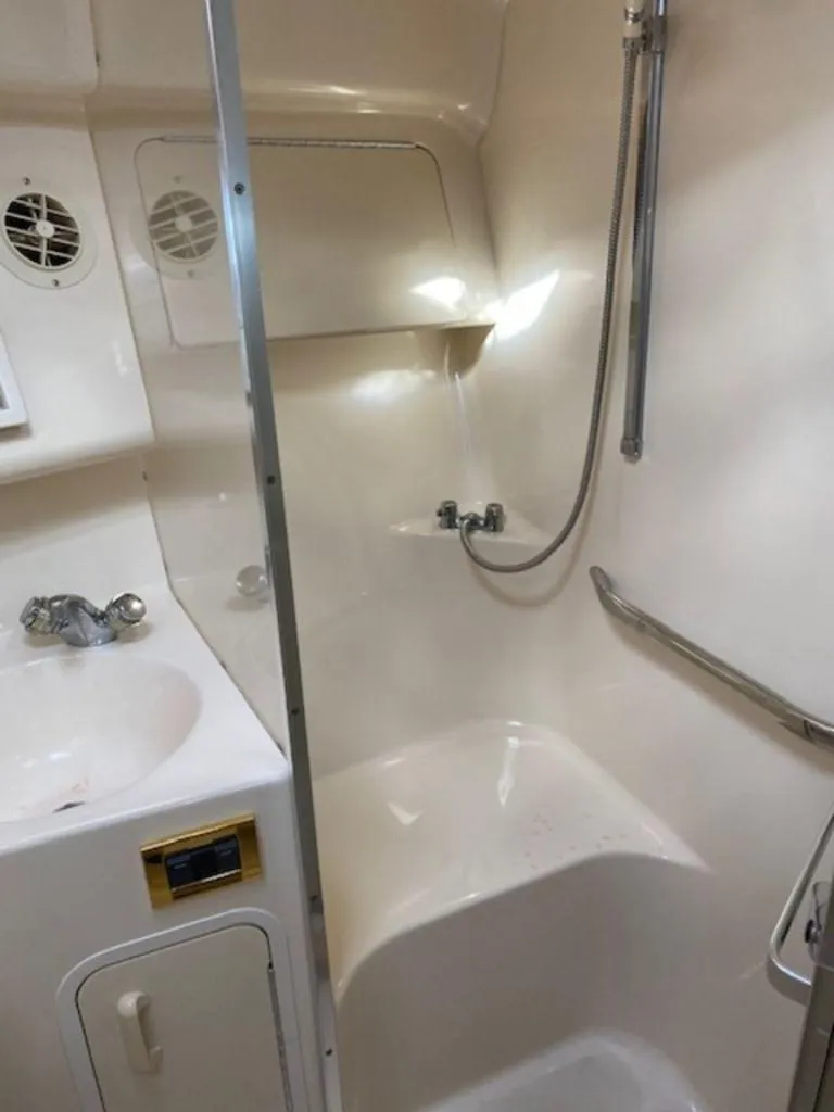 Slide: The Image of 1998 Sea Ray Sundancer 370 bathroom with shower, sink, and storage. - 21
