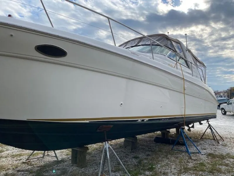Slide: The Image of 1998 Sea Ray Sundancer 370 yacht on stands, under cloudy sky. - 3