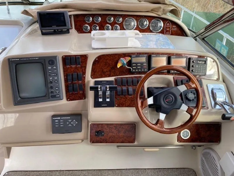 Slide: The Image of 1998 Sea Ray Sundancer 370 helm with wood accents and navigation instruments. - 5