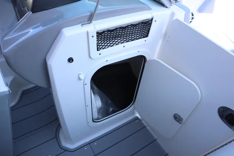 Slide: The Image of 2024 Chaparral 23 SSi OB boat storage compartment with open door. - 6