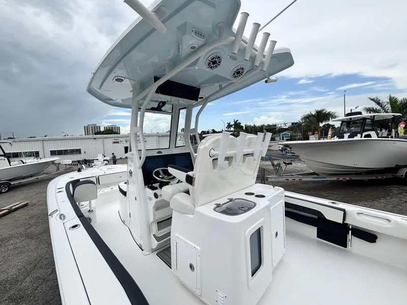 Slide: The Image of 2026 Tidewater 2700 Carolina Bay boat with modern helm and seating, docked under cloudy skies. - 12