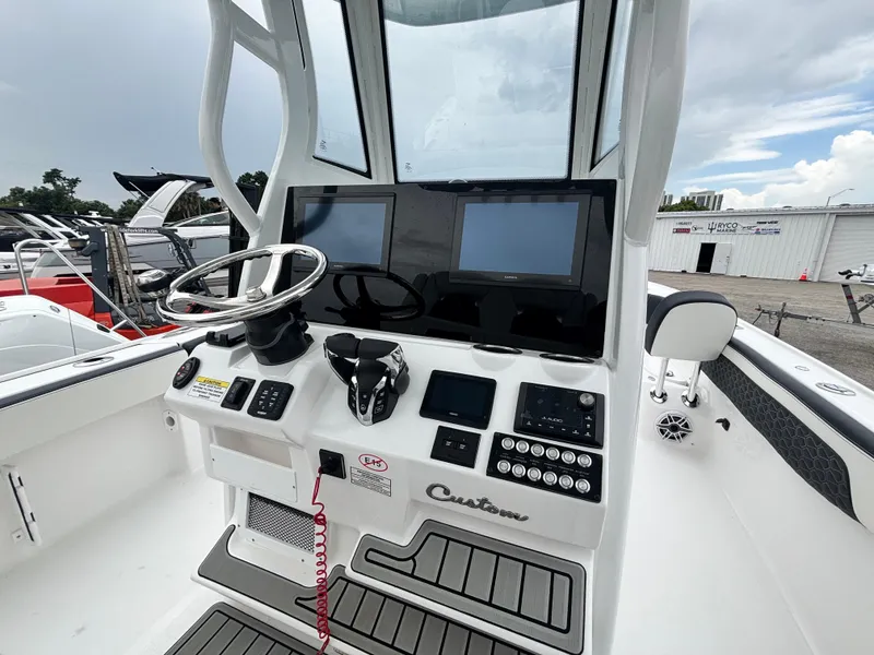Slide: The Image of 2026 Tidewater 2700 Carolina Bay boat dashboard with dual screens and steering wheel. - 15