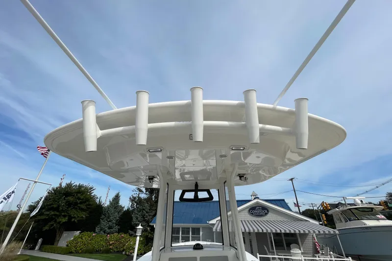 Slide: The Image of 2026 Regulator 25 boat with rod holders, viewed from below against a clear sky. - 21
