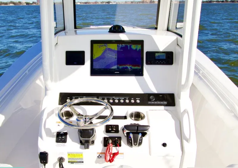 Slide: The Image of 2026 Regulator 25 boat with open storage compartment and cushioned seating. - 5