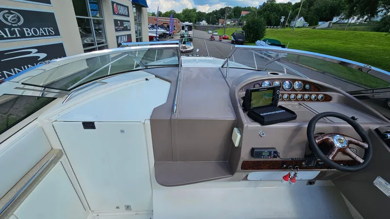 Slide: The Image of 2003 Regal Commodore 3260 boat dashboard with steering wheel and navigation equipment. - 14