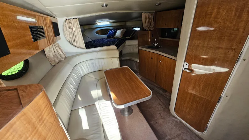 Slide: The Image of 2003 Regal Commodore 3260 cabin interior with wood finishes and cozy seating area. - 17