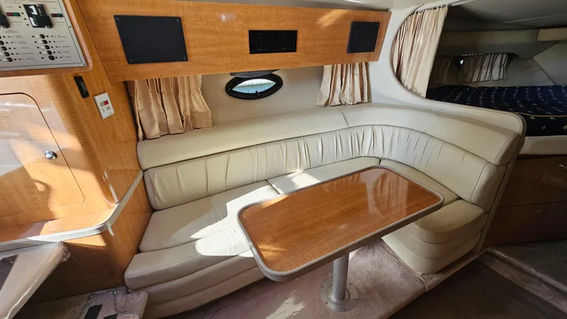 Slide: The Image of Interior of 2003 Regal Commodore 3260 yacht with leather seating and wooden table. - 19