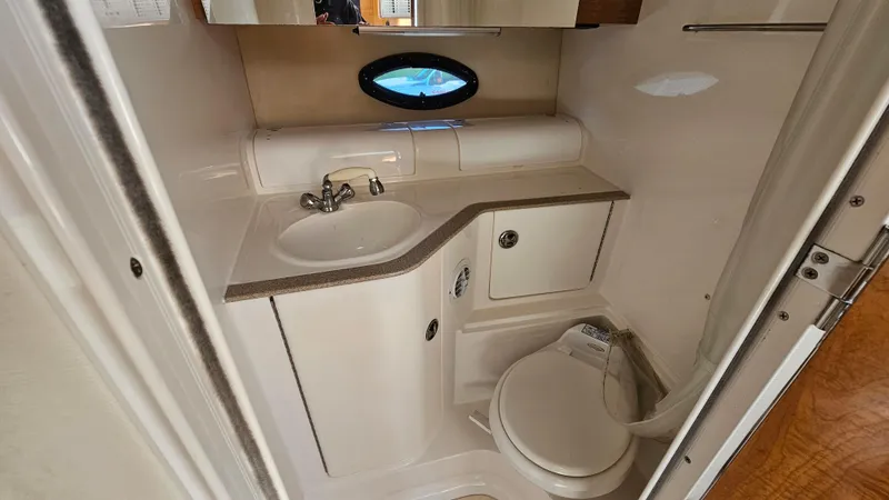 Slide: The Image of 2003 Regal Commodore 3260 boat bathroom with sink, toilet, and porthole window. - 27