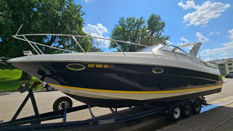 Slide: The Image of 2003 Regal Commodore 3260 boat on trailer, parked outdoors under a clear sky. - 3