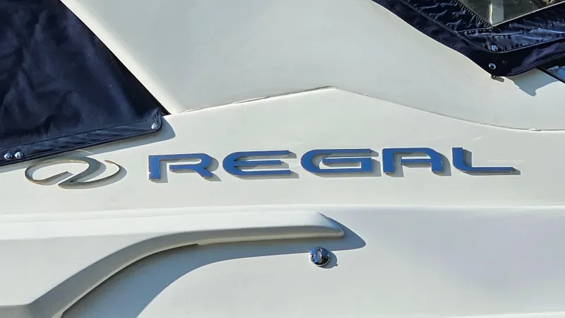 Slide: The Image of 2003 Regal Commodore 3260 boat logo on white hull. - 32