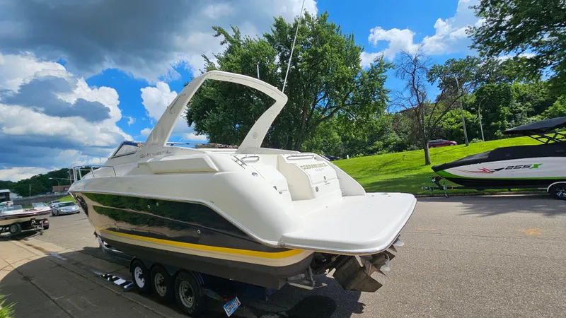 Slide: The Image of 2003 Regal Commodore 3260 boat on trailer, parked on a sunny street. - 4