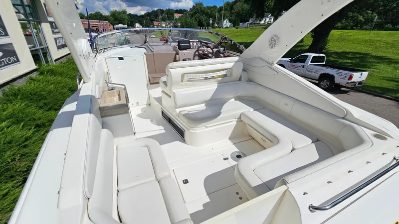 Slide: The Image of 2003 Regal Commodore 3260 boat interior with white seating and helm, parked outdoors. - 7