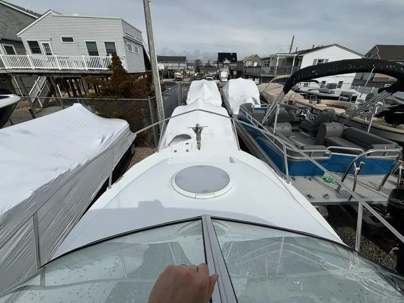 Slide: The Image of 2005 Polar 2300 Walkaround boat docked, featuring sleek design and spacious deck. - 10