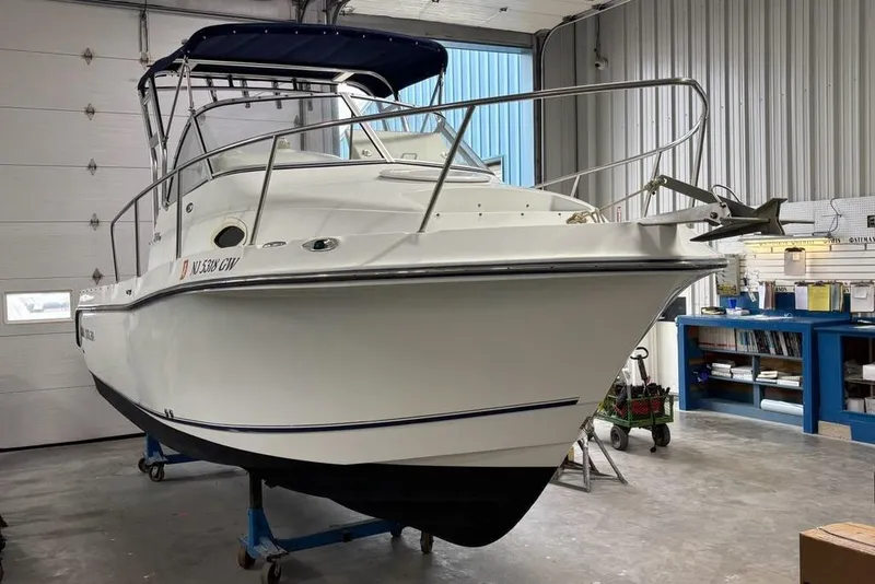 Slide: The Image of 2005 Polar 2300 Walkaround boat with 225 four-stroke engine, docked outdoors. - 26