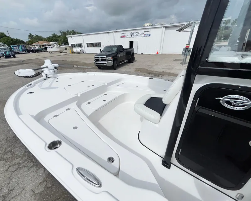 Slide: The Image of 2026 Tidewater 2210 Carolina Bay boat at a marina with a truck in the background. - 26