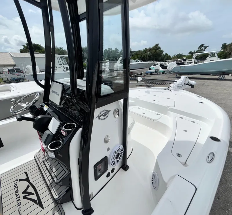 Slide: The Image of 2026 Tidewater 2210 Carolina Bay boat interior with console and seating, docked outdoors. - 27