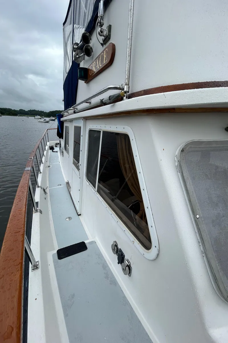 Slide: The Image of 1998 Monk 36 boat on water, featuring white exterior and wooden accents. - 16