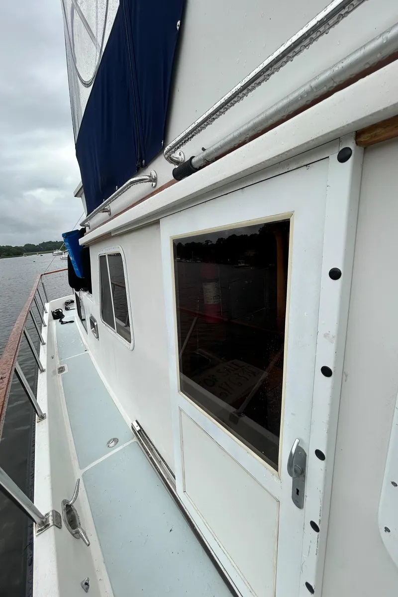 Slide: The Image of Side view of a 1998 Monk 36 boat with white exterior and blue canopy. - 17