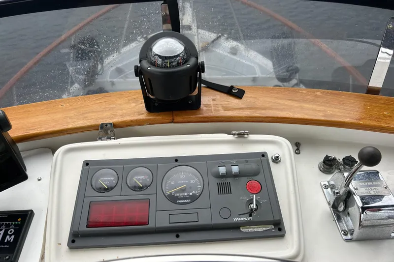 Slide: The Image of Boat control panel with compass, gauges, and throttle on a 1998 Monk 36 model. - 27
