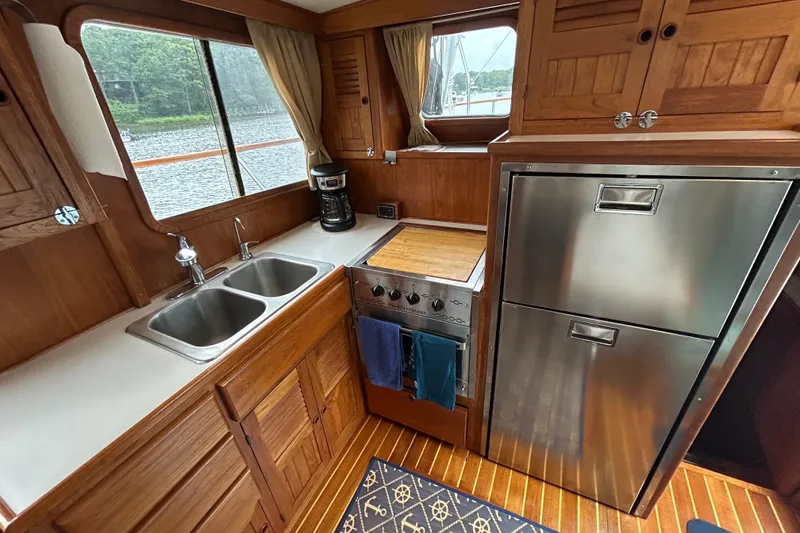Slide: The Image of Cozy kitchen in 1998 Monk 36 boat with wood cabinetry, stainless appliances, and dual sinks. - 3
