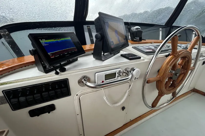 Slide: The Image of Boat helm with navigation equipment, wooden wheel, and control panel on a 1998 Monk 36. - 30