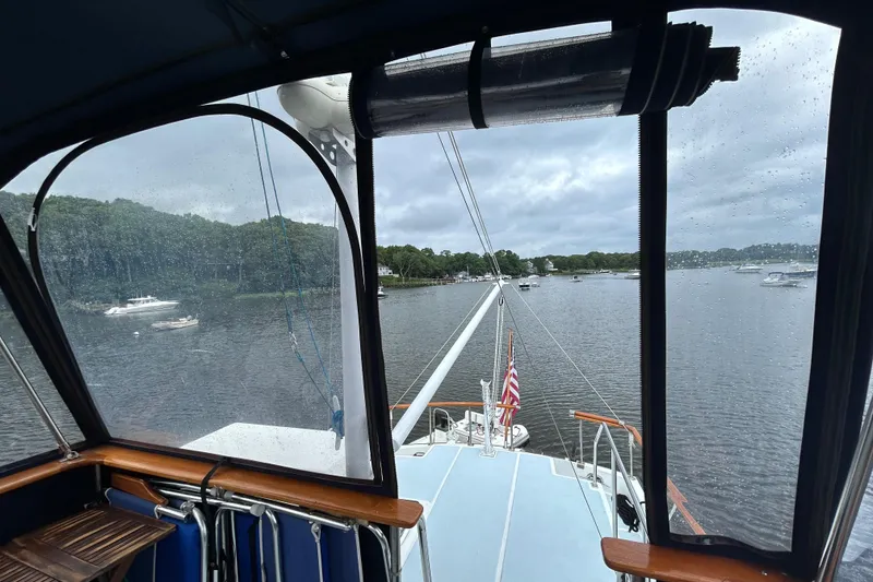Slide: The Image of View from 1998 Monk 36 boat cockpit, overlooking a serene river with moored boats. - 33