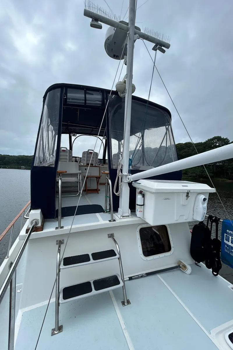 Slide: The Image of 1998 Monk 36 boat deck with seating, ladder, and equipment under cloudy sky. - 35