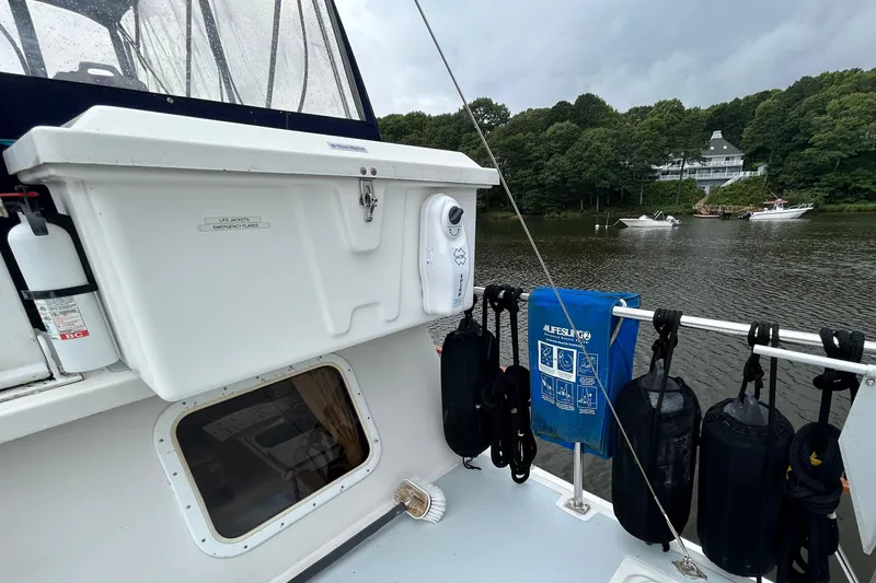 Slide: The Image of Boat deck with safety equipment, life jackets, and scenic river view; Monk 36, 1998 model. - 36