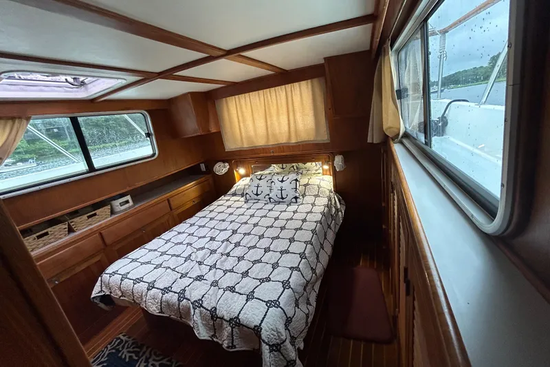 Slide: The Image of Cozy cabin interior of 1998 Monk 36 boat with nautical-themed bedding and wooden furnishings. - 4