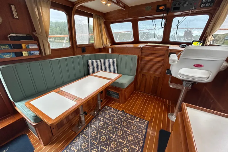 Slide: The Image of Cozy 1998 Monk 36 boat interior with wood paneling, cushioned seating, and nautical decor. - 41