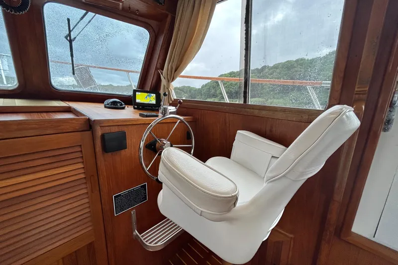 Slide: The Image of Helm of 1998 Monk 36 boat with white captain's chair and wooden interior. - 42