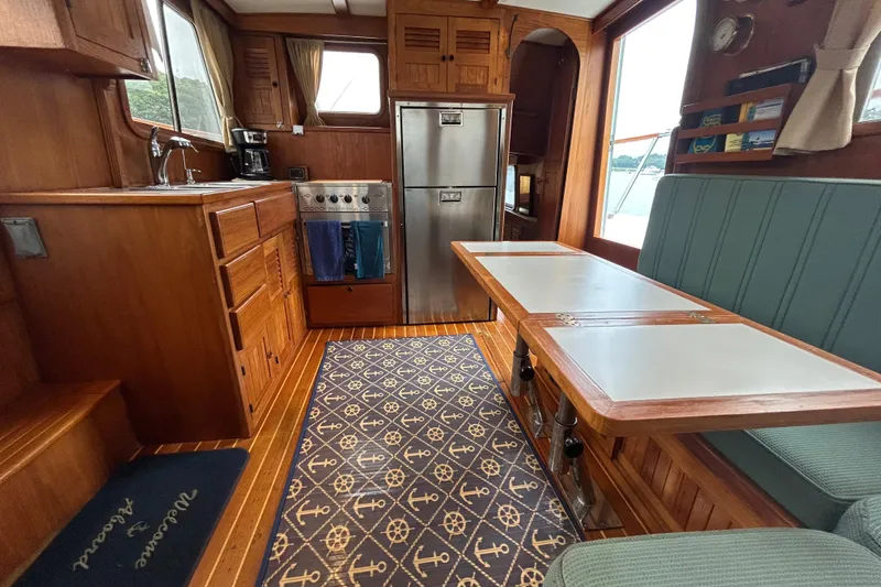 Slide: The Image of Cozy 1998 Monk 36 boat interior with wood finish, kitchenette, and dining area. - 44