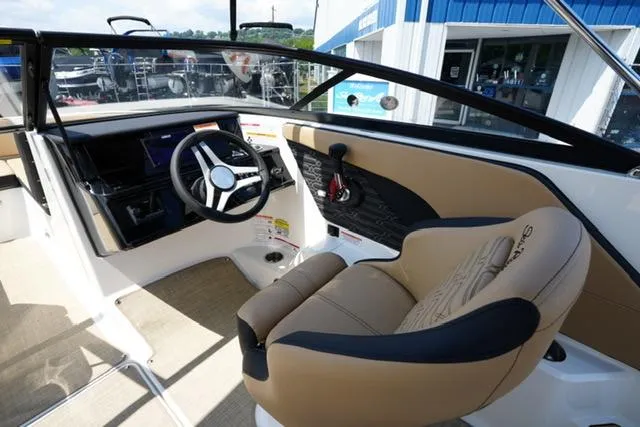 Slide: The Image of 2025 Sea Ray SPX 190 boat interior with steering wheel and beige seating. - 11