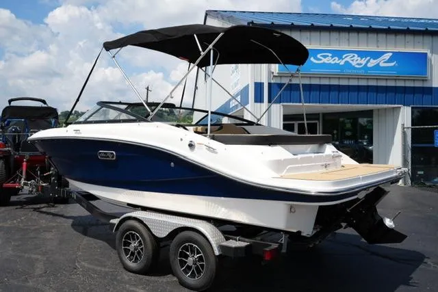 Slide: The Image of 2025 Sea Ray SPX 190 boat on trailer outside dealership, featuring sleek design and canopy. - 6