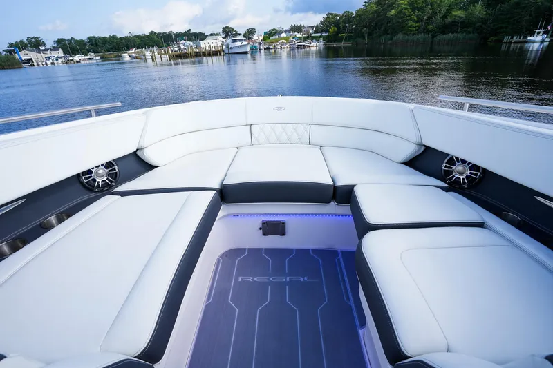 Slide: The Image of 2023 Regal 29 OBX boat interior with luxurious seating and scenic waterfront view. - 12