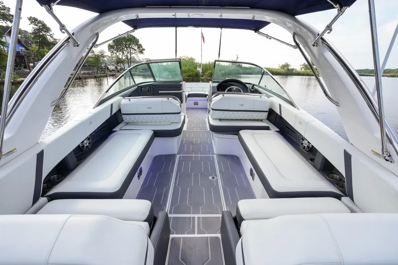 Slide: The Image of 2023 Regal 29 OBX boat interior with spacious seating and modern design on a calm lake. - 23