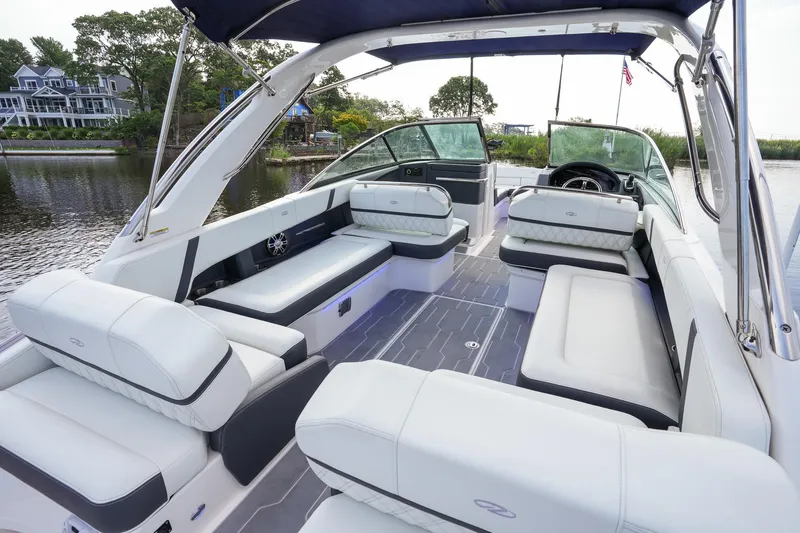 Slide: The Image of 2023 Regal 29 OBX boat interior with luxurious seating and modern design on a serene waterway. - 24