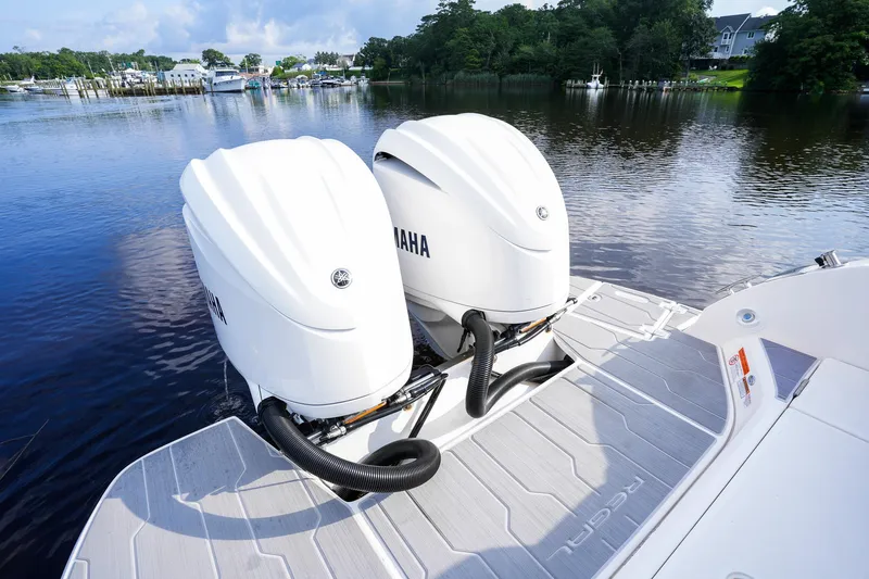 Slide: The Image of 2023 Regal 29 OBX boat with twin Yamaha outboard engines on a calm lake. - 26