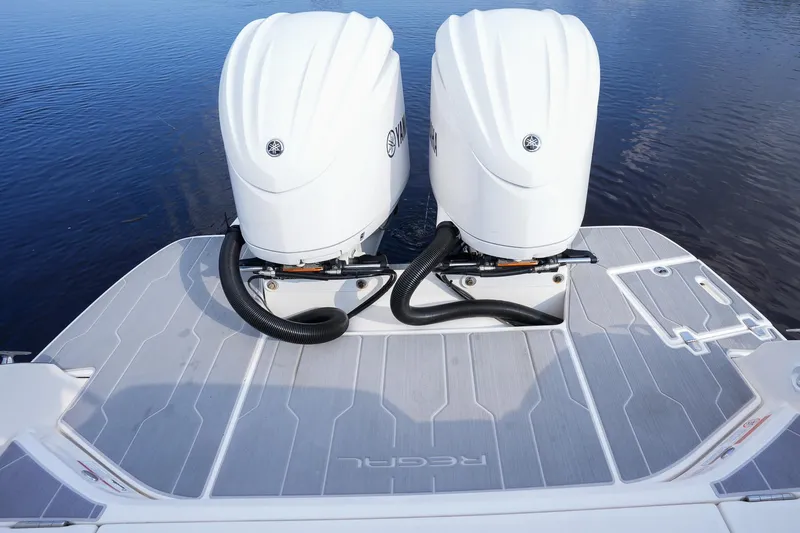 Slide: The Image of 2023 Regal 29 OBX boat with dual outboard engines on a calm water surface. - 27